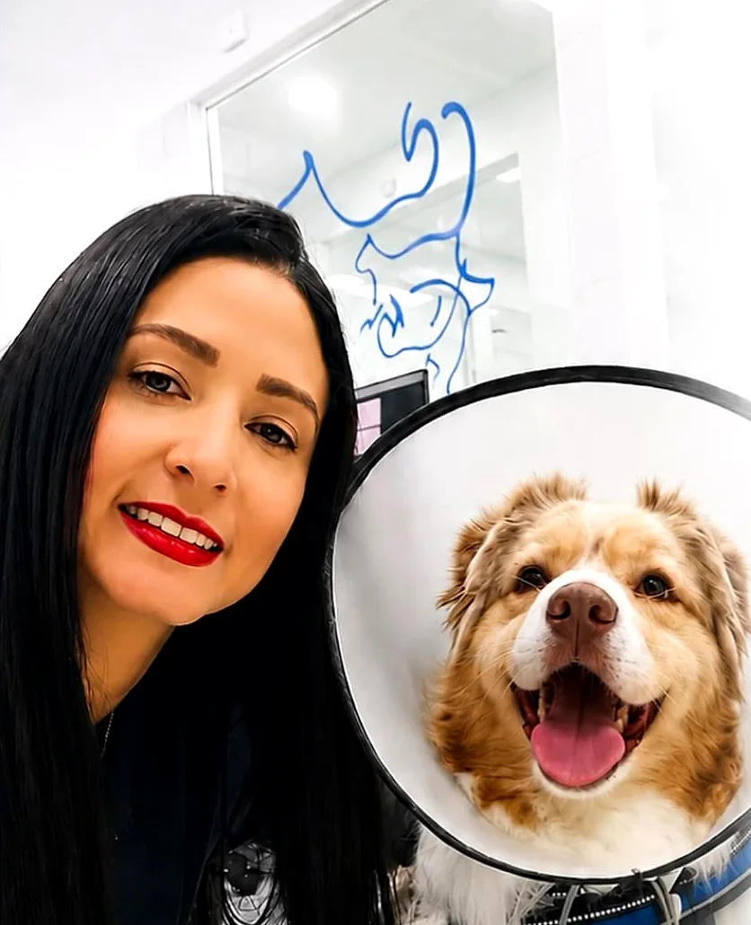 La Dra. Yoneidys Barrada sonriendo junto a un perro de pelo largo con collar isabelino