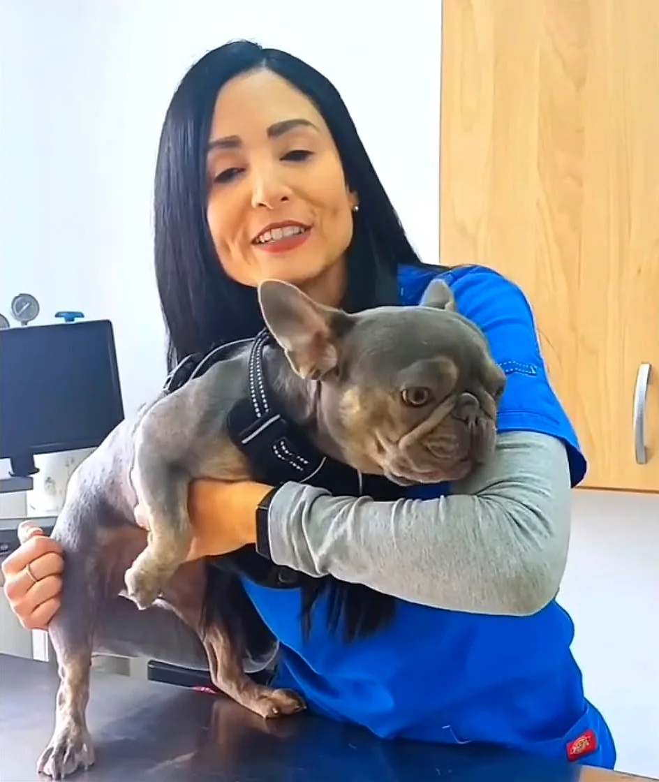 Retrato de la Dra. Yoneidys Barrada sosteniendo un perro pequeño en brazos